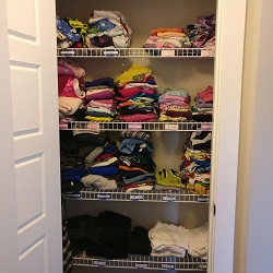 Organized kid clothes in a central closet 