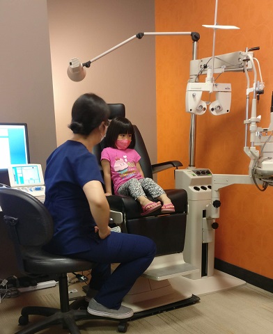Dr. Julie Dien-Fong giving a child an eye exam at the Vision Gallery in Edmonton. Tips on keeping kids' eyes healthy